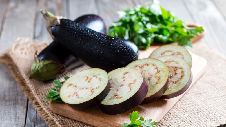 Eggplants in slices on wooden board