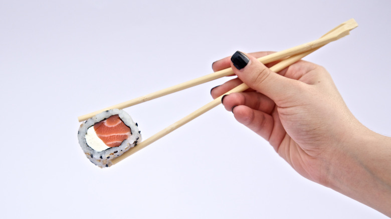Chopsticks holding sushi