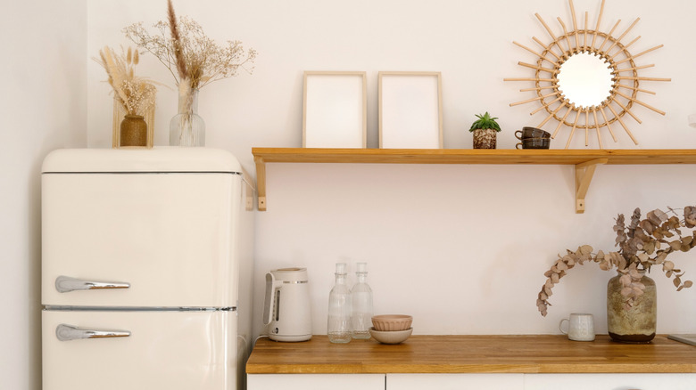 classic top freezer refrigerator in a neutral kitchen next to counter