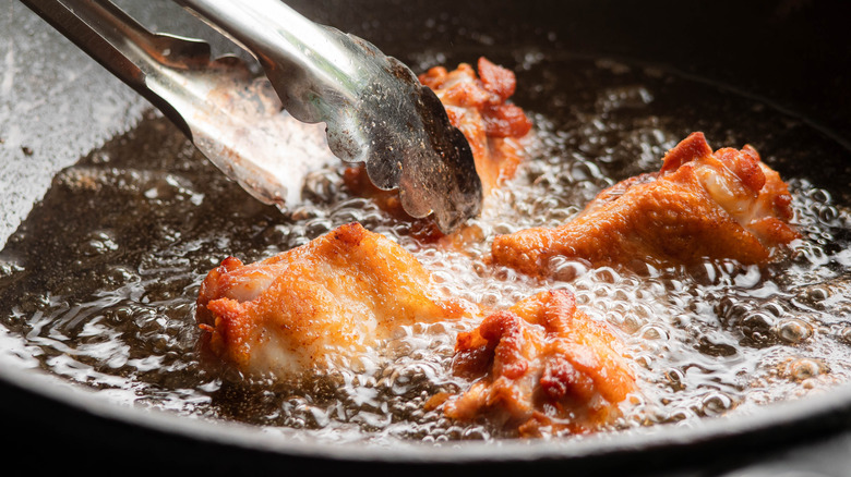 Chicken frying in a cast iron pan
