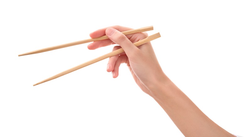 Hand holding chopsticks