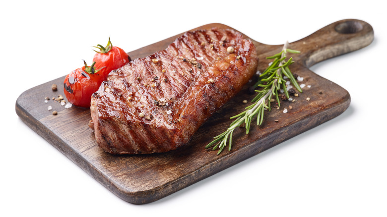 Cooked steak on a wooden board.