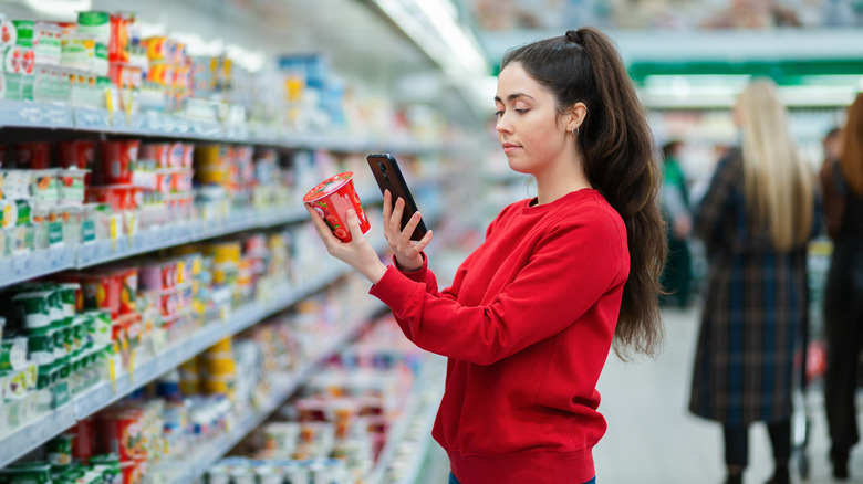 woman scanning yogurt in supermarket