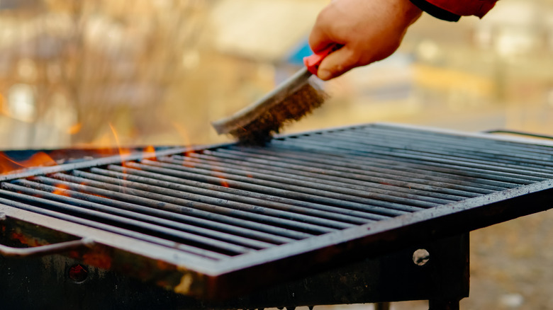 Someone brushing grill grates