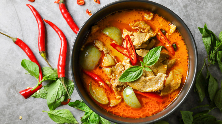bowl of spicy red curry with peppers and herbs