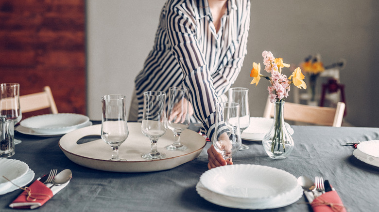Woman setting the table with plates