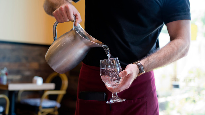 waiter pouring water into glass