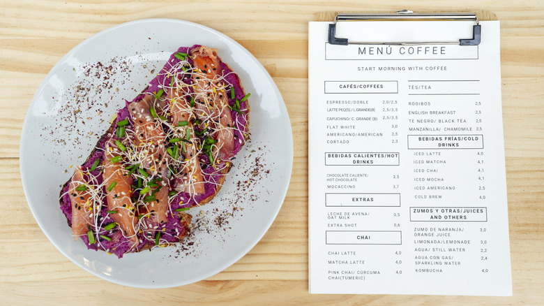 A menu next to a colorful cafe breakfast