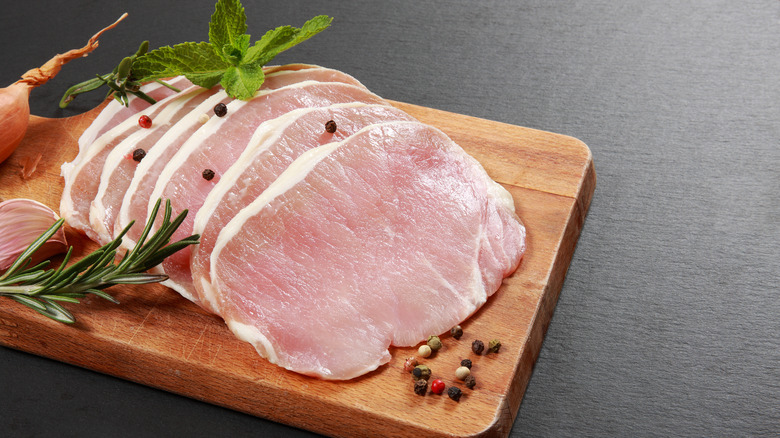 thin pork chops on wooden board