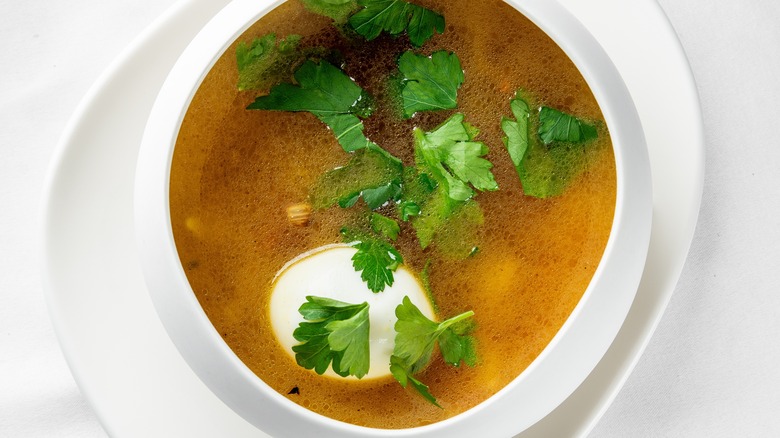 poached egg in broth with herbs