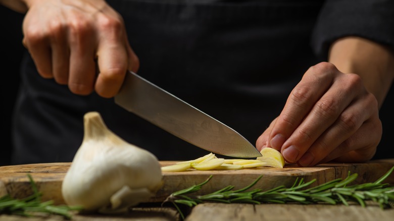 Hands cutting garlic