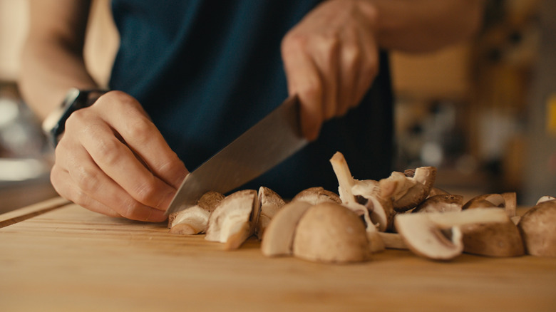 A person cuts mushrooms