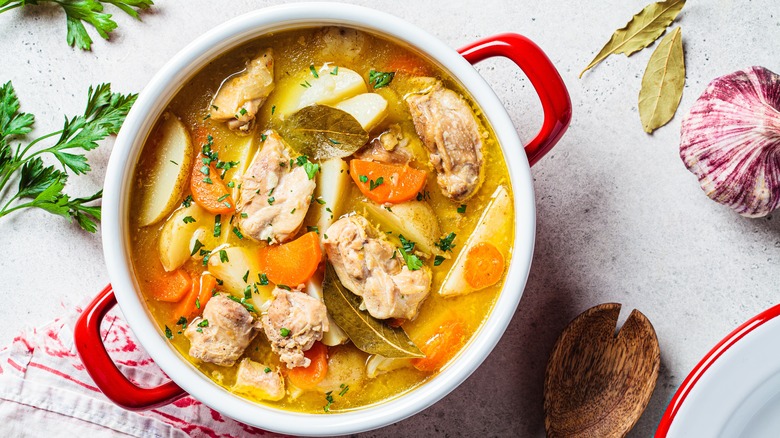 Chicken soup with carrots, potatoes, and bay leaves