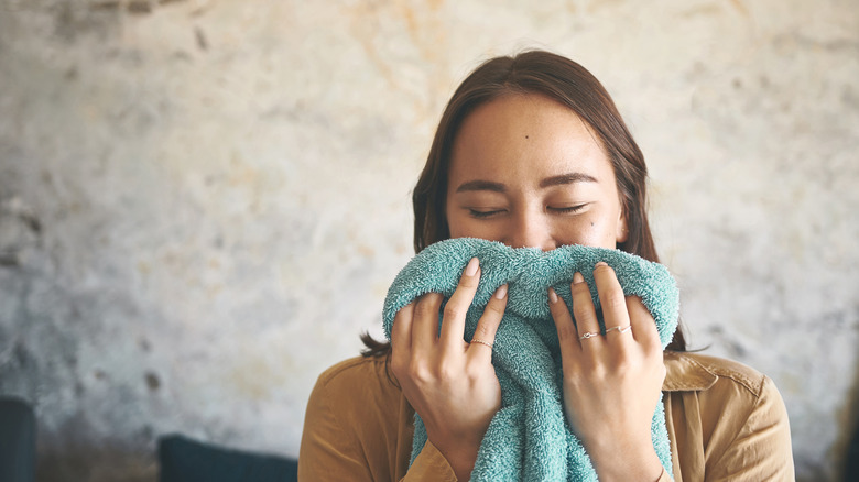 Woman smelling towel