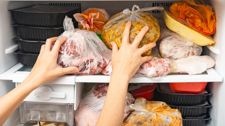 Person shoving food in a freezer