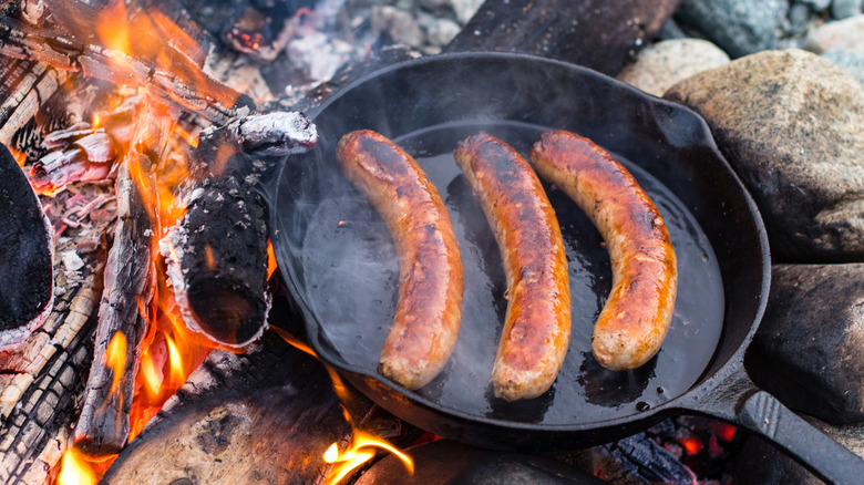 Cast iron pan on open fire with sausage