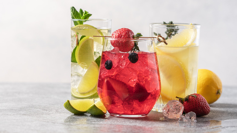 Three colorful drinks with fruit.