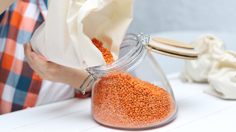 putting lentils in jar