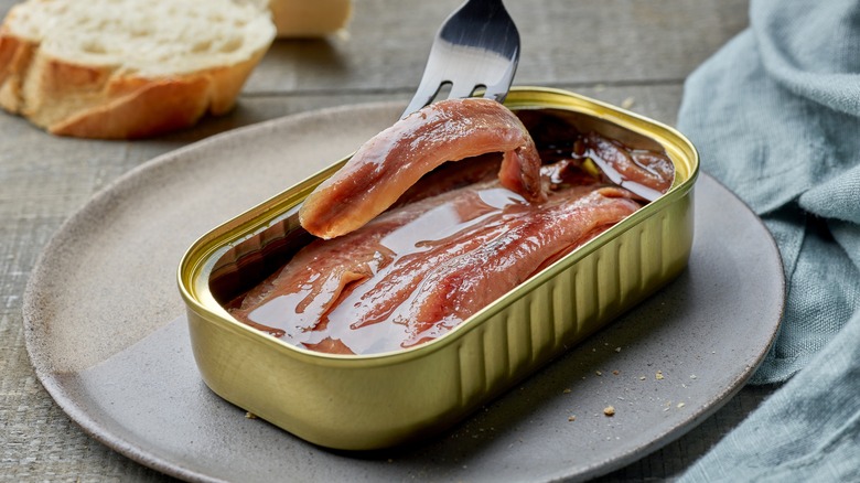 canned anchovies on a fork