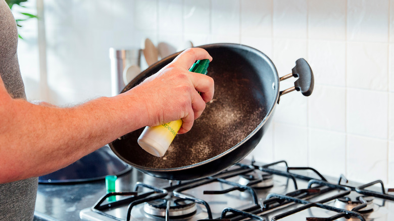 Spraying non-stick pan with oil