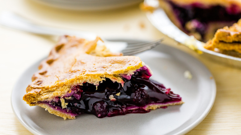 A slice of watery blueberry pie on a plate