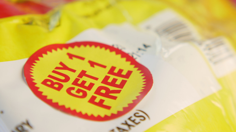 A red and yellow buy one get one free sticker on the label for some product