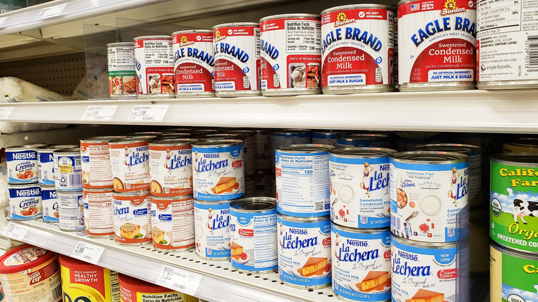 Store shelves featuring various brands of sweetened condensed milk