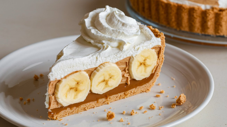 Slice of banofee pie topped with cream