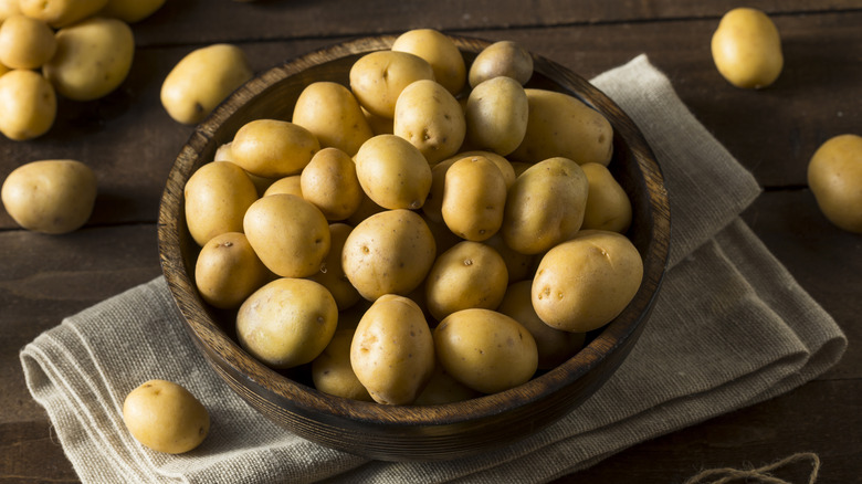 Yukon Gold potatoes in a wood bowl waiting to be chuffed and roasted.