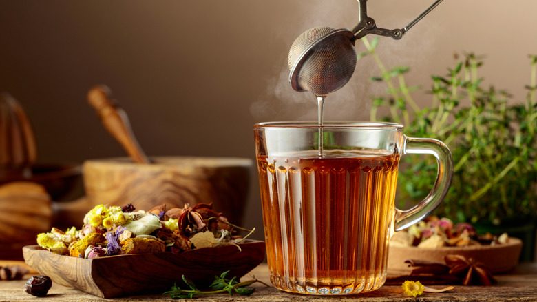 a tea strainer lifting out of a cup of tea