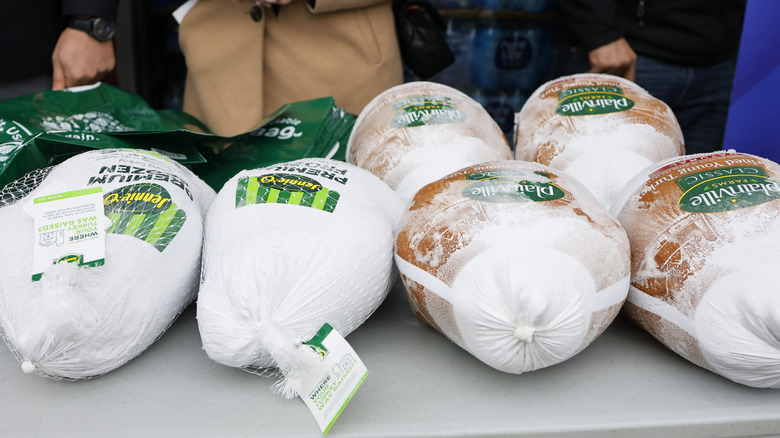 Several frozen turkeys displayed on a table