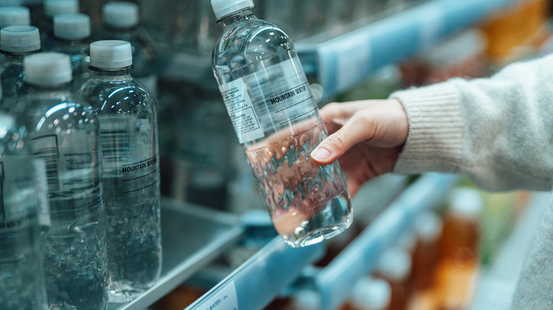 A person picks up a plastic bottle from a supermarket