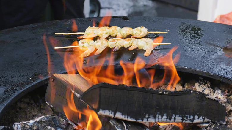 Skewers of shrimp over wood-fired pit