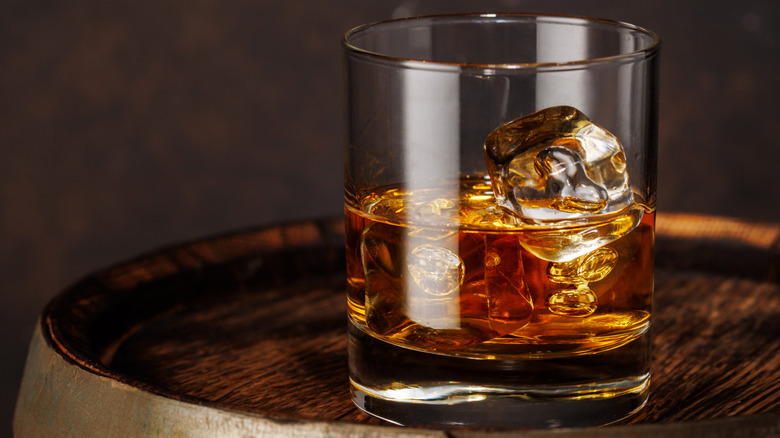 Iced bourbon glass on barrel