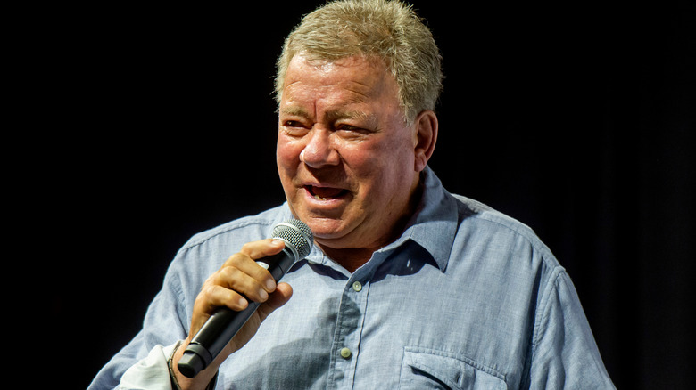 William Shatner with microphone in hand.