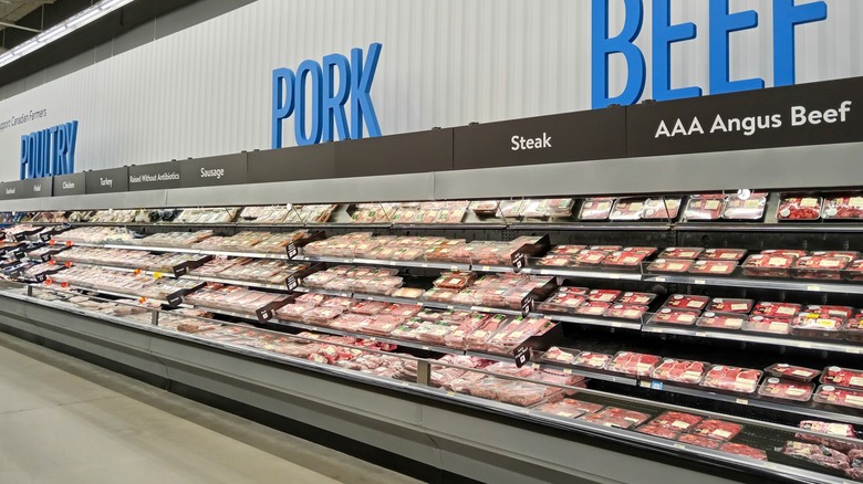 Fresh meat department displays a variety of meats including pork, beef, and poultry in a Walmart grocery store located in Canada.