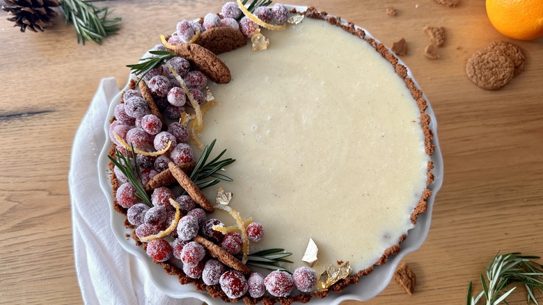 white tart with sugared cranberries and rosemary