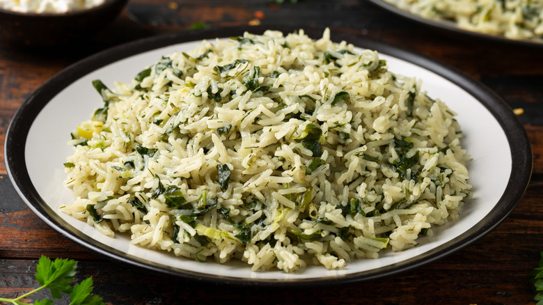 A plate of rice with greens mixed throughout