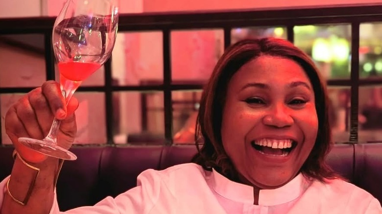 Michelin Star chef Adejoké Bakare smiling with glass of wine