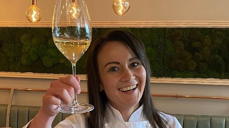 Michelin Star chef Lorna McNee raising a glass of wine