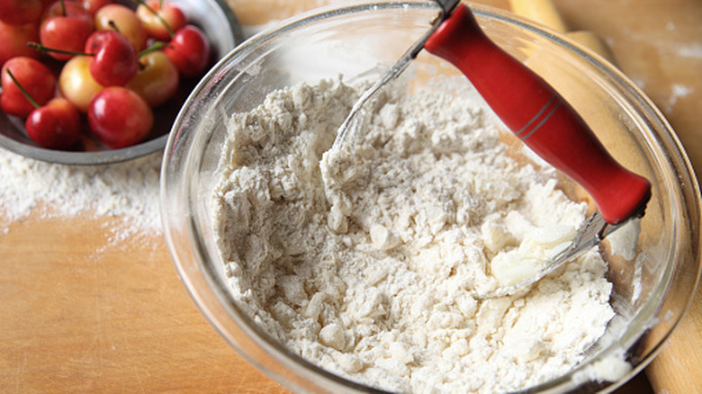 a bowl of dough with a pastry blender sitting in it