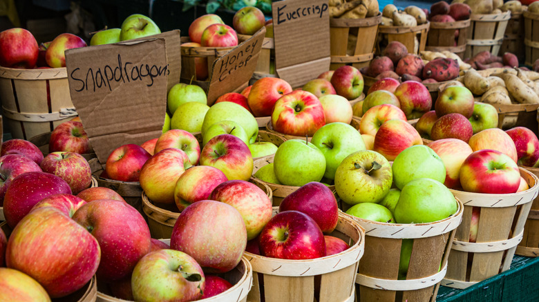 Wooden bins of different kinds of apples at a market