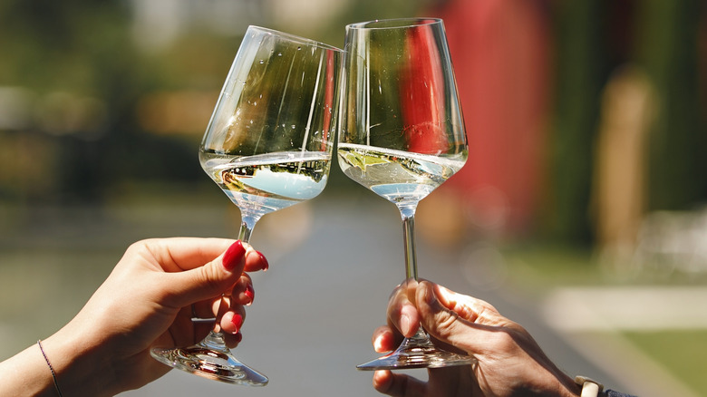 White wine in glasses clinking