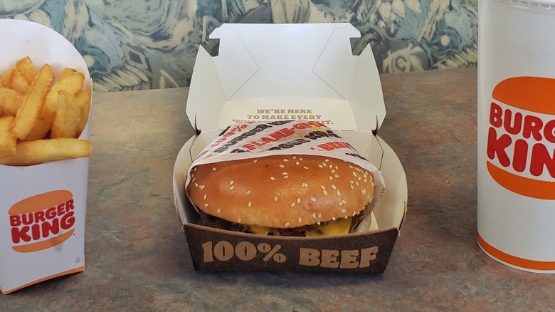 A Maple Bourbon BBQ Whopper in a box next to fries and a drink