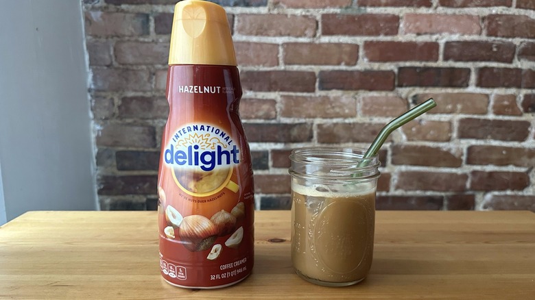 International Delights hazelnut coffee creamer beside a glass jar of iced coffee