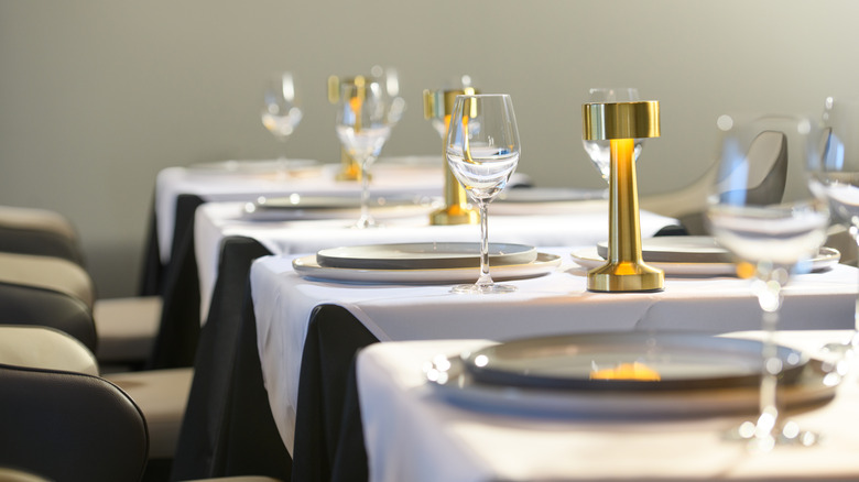 gold lamps and white plates on fine dining restaurant table
