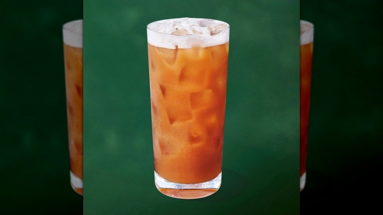 Starbucks Iced Chaider drink in glass against dark green background