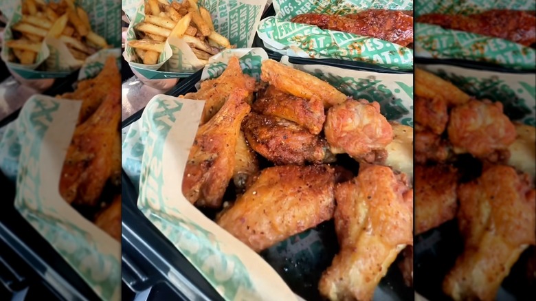 Food from Wingstop in to-go containers including Lemon Pepper Chili Crunch chicken wings and French fries