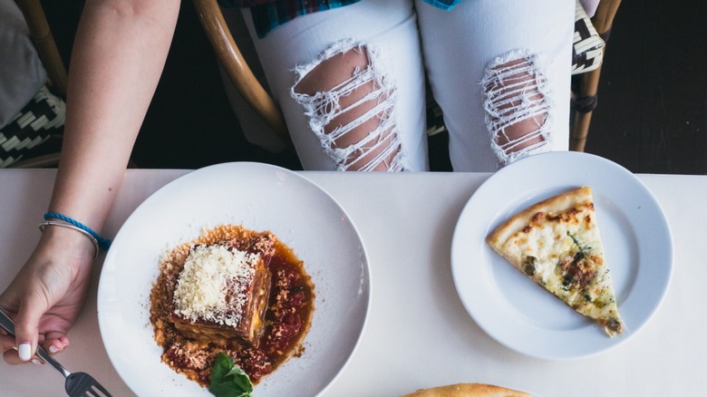 Lower body of a person wearing ripped jeans at a nice restaurant