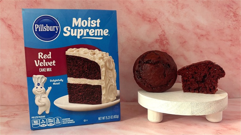 Pillsbury's red velvet cake mix box with a cupcake and a half cupcake on tray